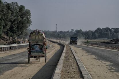 Un tuc-tuc circulando por la nueva carretera que unirá Bangladés con Birmania; la carretera está construida con una parte de trabajadores rohingya del campo de refugiados.