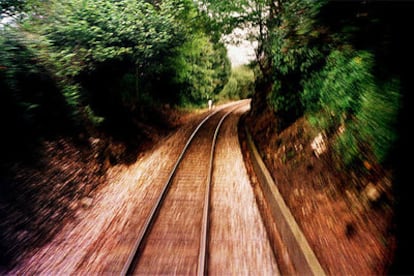 Los raíles de la línea de ferrocarriles de vía estrecha, en un tramo boscoso de Cantabria.