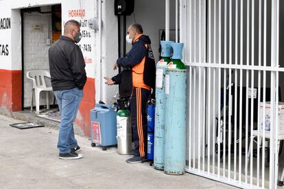 Gustavo Alvarado habla con un cliente frente a su tienda de oxígeno, que abrirá próximamente.