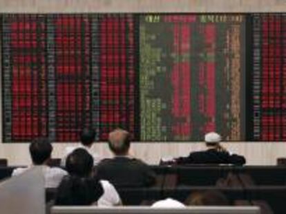 Inversores surcoreanos estudian la información bursátil en Seúl (Corea del Sur).