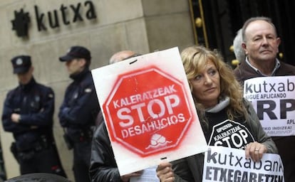 Miembros de Kaleratzeak Stop Desahucios e IRPH-STOP de Gipuzkoa participan en una concentraci&oacute;n frente a la sede de Kutxanank en San Sebasti&aacute;n.