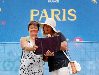 Unas turistas se toman un selfi frente a un cartel publicitario de París en el verano de 2016 durante la final de la Eurocopa.