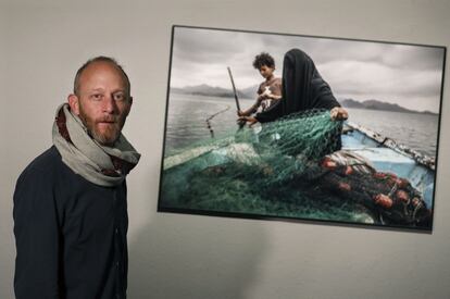 Pablo Tosco, premiado en el World Press Photo 2021 en la categoría de Asuntos contemporáneos, posa junto a su fotografía sobre Fátima de Yemen, en la exposición del CCCB.