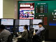 Trabajadores del banco Hana observan los movimientos de la Bolsa tras el alto al fuego entre Estados Unidos e Irán en Seúl (Corea del Sur).