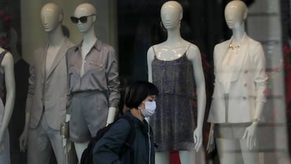 Una mujer pasa frente al escaparate de una tienda de ropa cerrada en Londres.