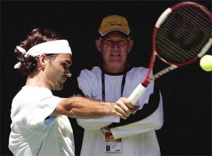 Federer golpea la pelota ante la atenta mirada de Tony Roche