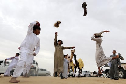 Alegría de un grupo de emiratíes tras ganar la carrera de camellos celebrada en el festival.