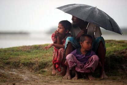 Los refugiados rohingya se resguardan de la lluvia mientras esperan recibir el permiso del Ejército de Bangladés para continuar su camino después de cruzar la frontera entre Bangladés y Myanmar, en Teknaf.