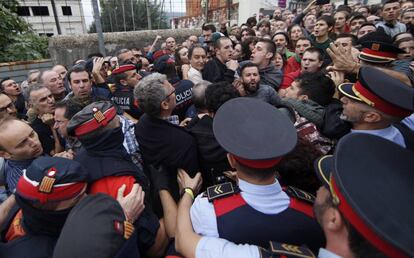 Agentes de los Mossos d'Esquadra intentan acceder al centro donde estaba previsto que vote el vicepresidente de la Generalitat de Cataluña, Oriol Junqueras.