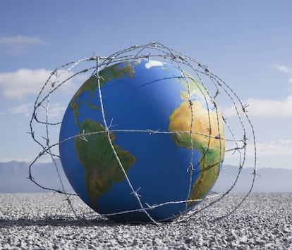 Un globo terráqueo envuelto en una alambrada de espinos en el suelo