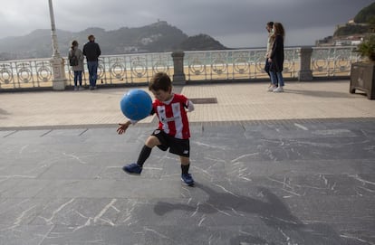 Un niño vestido con la equipación del Athletic juega con un balón, este viernes en San Sebastián.