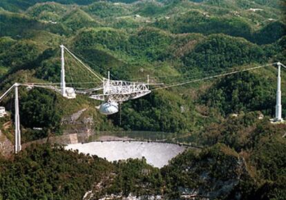 La antena de 305 metros de diámetro del radiotelescopio de Arecibo (Puerto Rico) está montada entre montañas (izquierda).