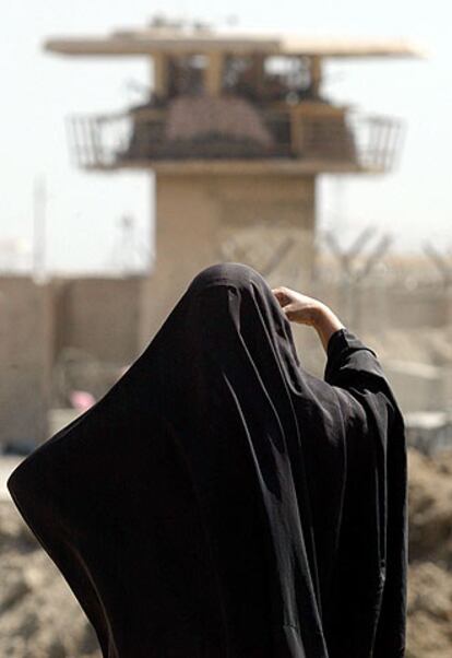Una mujer, ante una torre de la prisión de Abu Ghraib.
