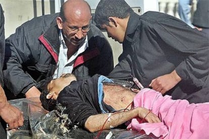 Un hombre malherido es trasladado a un hospital tras el atentado contra la mezquita de Kadhmain.