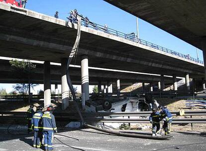 Varios bomberos inspeccionan la zona junto a la furgoneta siniestrada.