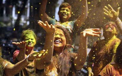 Jóvenes indios se lanzan polvos de colores durante la celebración del festival Holi en Bombai (India).