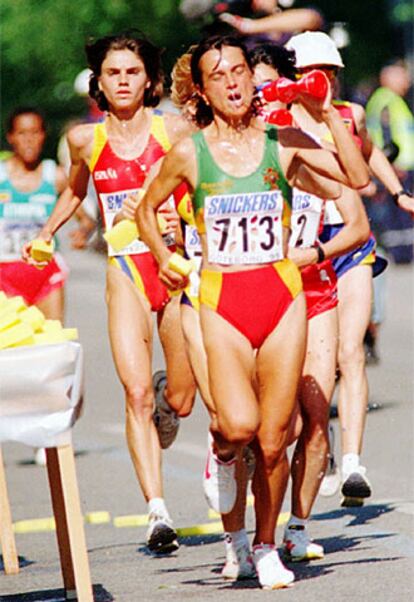 Varias corredoras de maratón recogen agua durante una carrera.