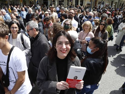 La escritora Lucia Lijtmaer sujeta un ejemplar su último libro 'Cauterio' durante la celebración de Sant Jordi, en Barcelona.