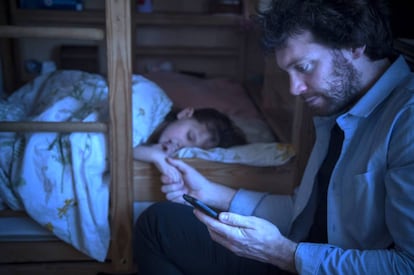 Un padre consulta el móvil.