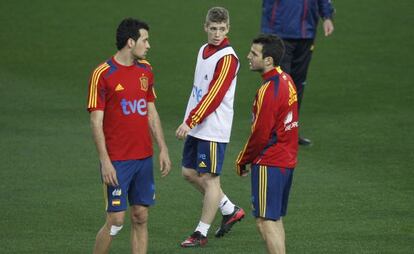 Muniain, durante el entrenamiento de ayer, entre Busquets y Cesc.