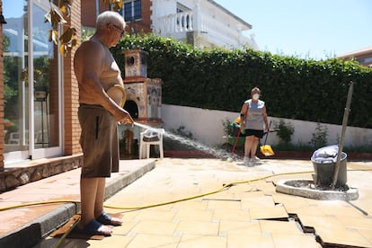 Un vecino de la urbanización de Calypo Fado, en Casarrubios del Monte, Navalcarnero, enfría su jardín. 