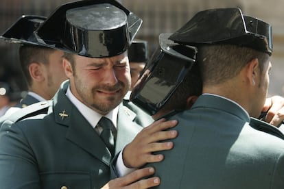 Un agente llora desconsolado mientras otros dos se abrazan, durante el funeral por los miembros de la Guardia Civil Diego Salvá y Carlos Sánez de Tejada, asesinados en un atentado de ETA en Palmanova (Mallorca), el 31 de julio de 2009.