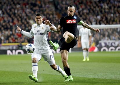 El centrocampista del Real Madrid Casemiro (i) pelea un balón con el centrocampista eslovaco del Nápoles Marek Hamsik.