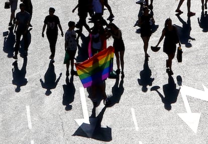 Varias personas con una bandera arcoíris, en el desfile del Día del Orgullo Gay en Madrid.