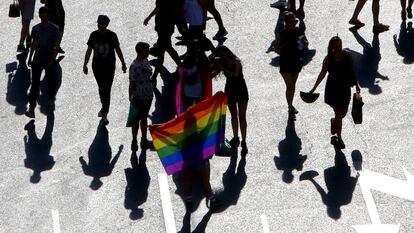 Varias personas con una bandera arcoíris, en el desfile del Día del Orgullo Gay en Madrid.