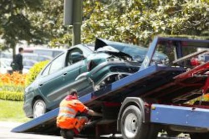 Una gr&uacute;a retira un coche siniestrado.