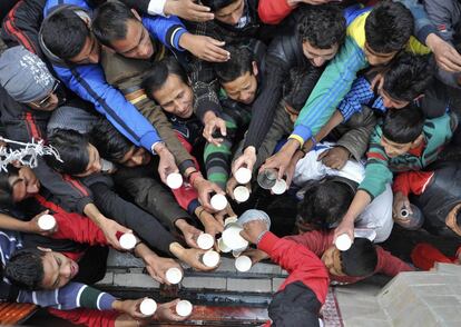 Los devotos hindúes se agolpan para recibir ofrendas que son repartidas dentro de un templo, en ocasión del festival de Mahashivratri en Shimla (India).