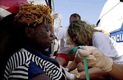 Una mujer es atendida tras desembarcar de una patera en una playa de Cádiz el pasado 24 de julio.