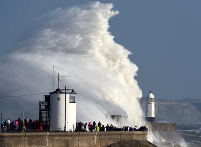 Vista de un faro contra el que las olas chocan de manera brusca debido a los efectos de la tomenta Ophelia en Porthcawl (Gales).