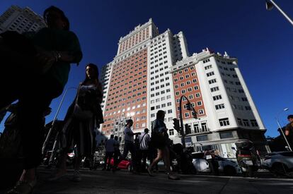 La gente camina por enfrente del edificio sobre la Gran Vía