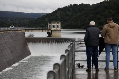 Unas personas observan el embalse de San Rafael de Navallana en Córdoba que vierte sus aguas al río Guadalmellato, este martes.