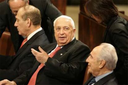 Sharon (centro), flanqueado por el viceprimer ministro, Ehud Olmert (izquierda), y el adjunto al primer ministro, Simón Peres, ayer.