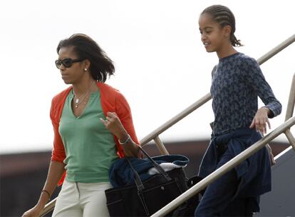 La familia del presidente electo de EE UU, Barack Obama, llegó ayer a Honolulu, lugar en el que Obama vivió parte de su infancia y donde pasarán las últimas vacaciones navideñas antes de ser los nuevos inquilinos de la Casa Blanca. En la imagen, Michelle y Malina Obama, descienden del avión que les trasladó a la isla.