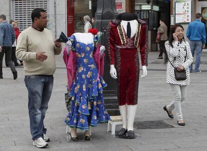 Un vendedor trata de llamar la atención de los turistas, en la Puerta del Sol de Madrid.