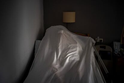 El cuerpo de un anciano víctima del coronavirus descansa tapado con una sábana sobre una cama en un centro de mayores en Barcelona.