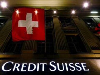 Logo de Credit Suisse bajo la bandera nacional suiza, en Berna (Suiza).