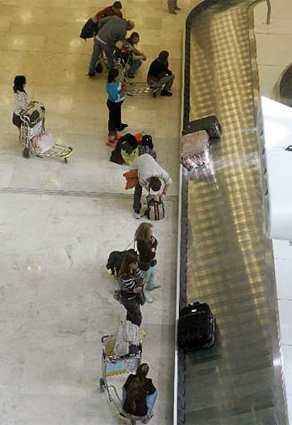 Pasajeros recogen el equipaje en la nueva T4 de Barajas.