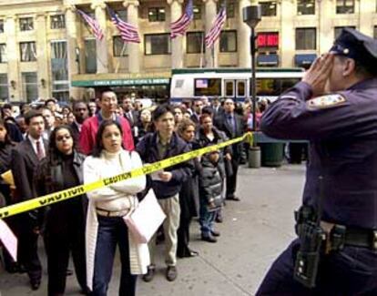 Un policía da instrucciones a desempleados concentrados ante el Madison Square Garden el pasado día 17.