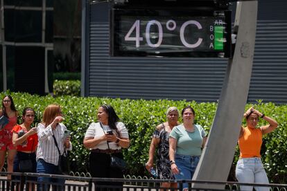 Personas caminan en la avenida Paulista, dónde los termómetros urbanos registran una temperatura de 40,0 grados centígrados, este martes, en la ciudad de São Paulo (Brasil).