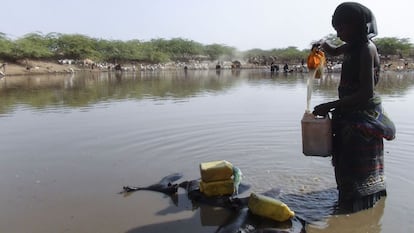 Una mujer etíope recoge agua de un estanque construido para mejorar la resiliencia frente a la sequía.