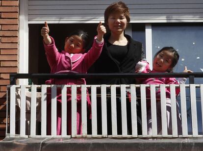 Wei Chen i les seves filles saluden des de la finestra del pis on viuen al Fort Pienc. 