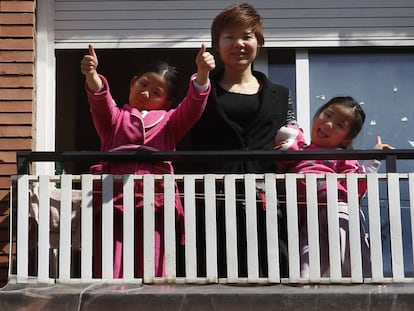 Wei Chen i les seves filles saluden des de la finestra del pis on viuen al Fort Pienc. 