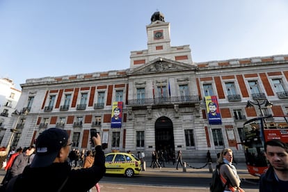 Un turista fotografía la fachada de la Real Casa de Correos, sede de la Presidencia del Gobierno de la Comunidad de Madrid, con dos lonas en apoyo al Leopoldo López.