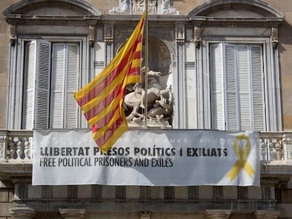 Fachada del Palau de la Generalitat de donde cuelga, junto a la bandera catalana, un cartel y un lazo amarillo reivindicando la libertad de los políticos encarcelados.