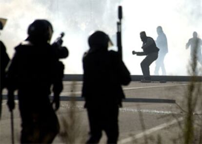 Los manifestantes se enfrentan a la policía en los accesos a las instalaciones del puerto.