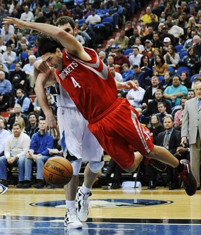 El alero argentino de Houston, Luis Scola, se cae al suelo cuando Kevin Love, de Minnesota, le roba el balón durante el partido de anoche.